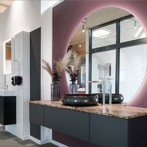 Ein modernes Badezimmer mit einem eleganten Waschbecken und einer stilvollen Holzplatte, umgeben von minimalistischen Möbeln.