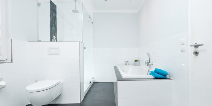 Ein modernes Badezimmer mit einer eleganten Badewanne und einer separaten Dusche, alles in strahlendem Weiß gehalten.