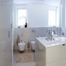Ein modernes Badezimmer mit hellen Wänden, großen Fenstern und eleganten Armaturen, das eine entspannende Atmosphäre ausstrahlt.